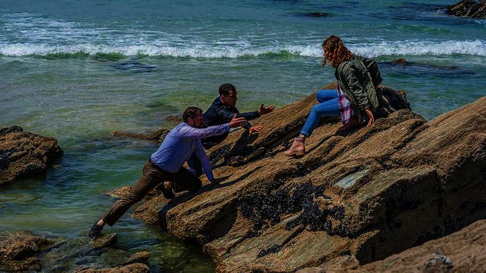  Lisa (Johanna Hens) ist auf einem Felsen eingeschlafen. Julian (Mathias Harrebye Brandt) und Vince (Gabriel Merz) kommen gerade noch rechtzeitig, um sie vor dem steigenden Wasser zu retten. Bild: Sender / ORF / ZDF / Jon Ailes